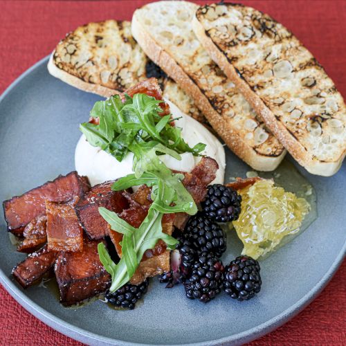 A plate with grilled chicken, veggies, and two tortillas or flatbreads on the side, bright and colorful.