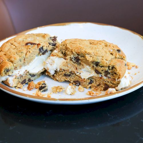 A plate of tacos or quesadillas with melted cheese and herbs on a tortilla, served on a black surface.